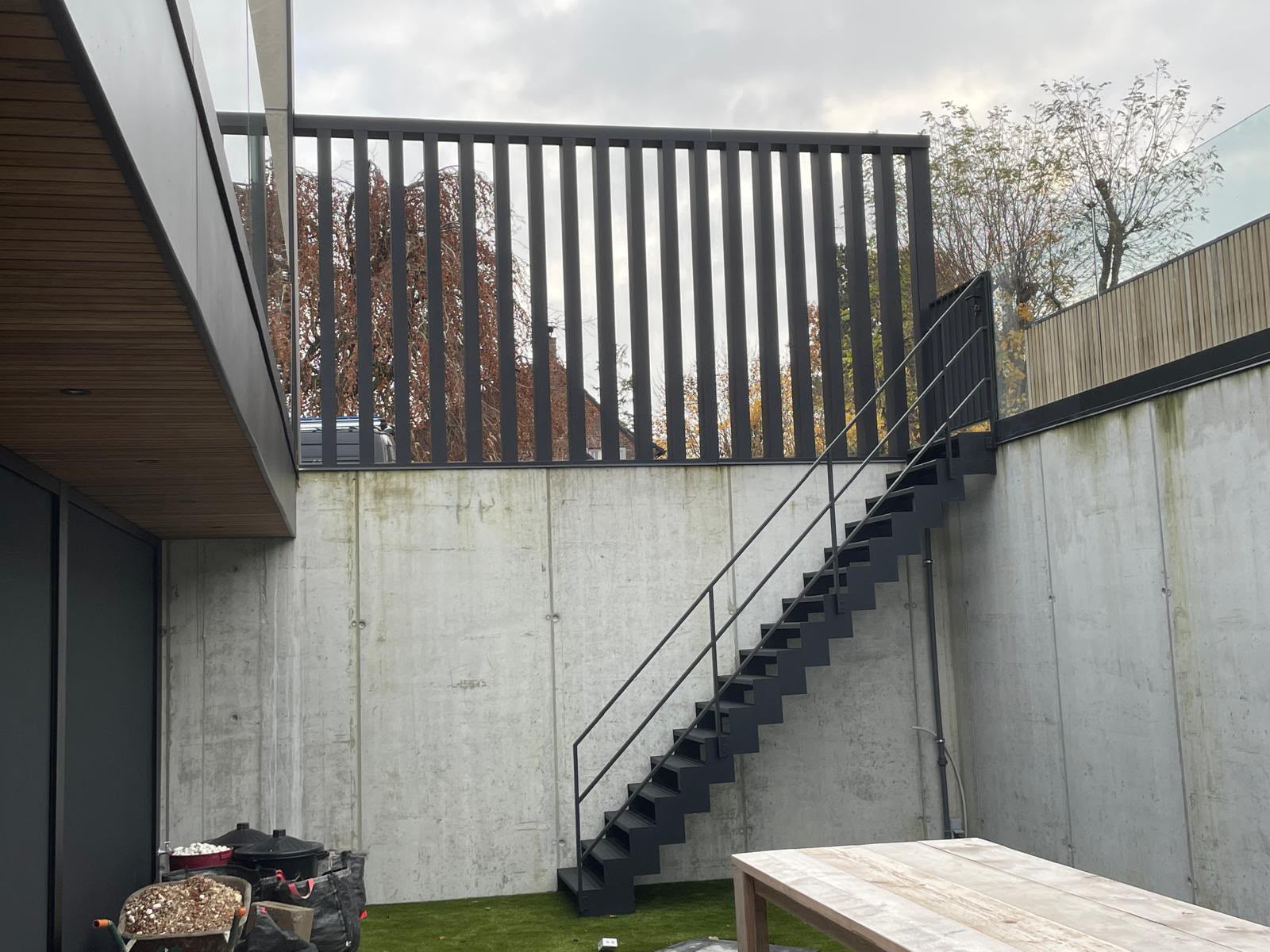 Zwarte buitentrap met balustrade bij moderne woning